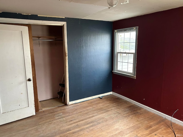 unfurnished bedroom featuring a closet and light hardwood / wood-style flooring