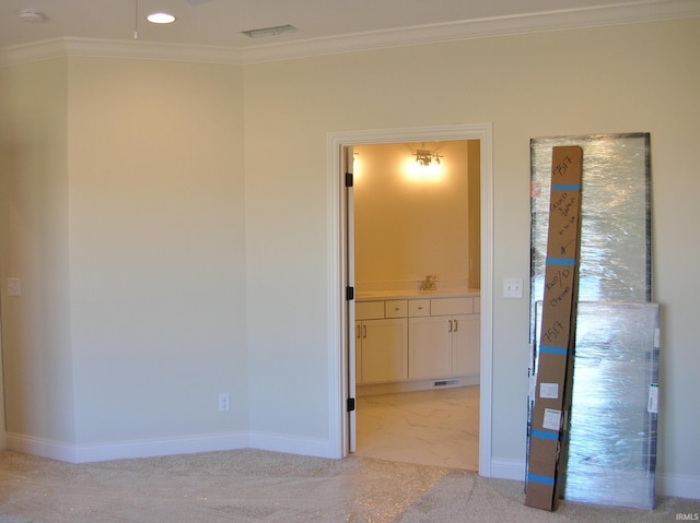 carpeted spare room with ornamental molding and sink