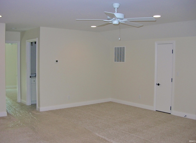 empty room with ceiling fan and light carpet