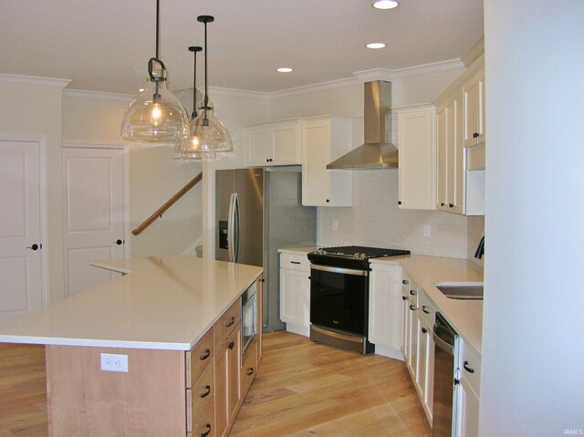 kitchen featuring appliances with stainless steel finishes, tasteful backsplash, a kitchen island, wall chimney range hood, and white cabinetry