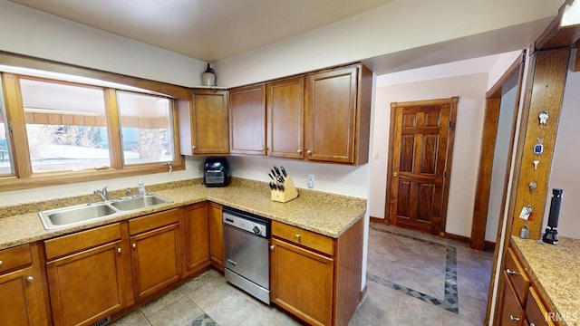 kitchen featuring light stone counters, sink, light tile floors, and dishwasher