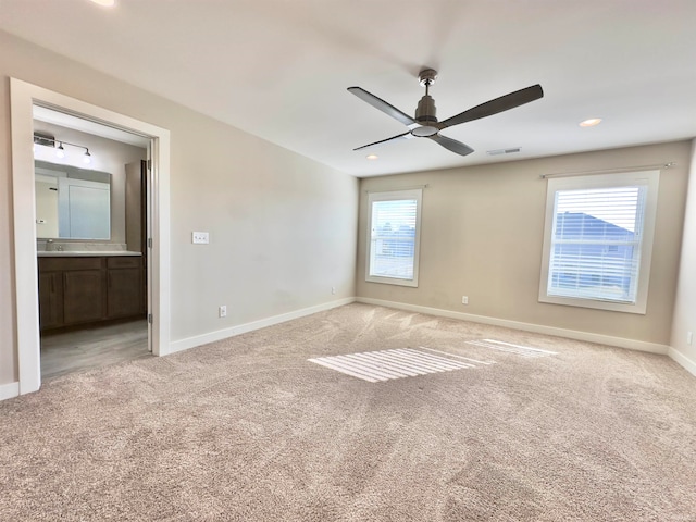 carpeted empty room featuring ceiling fan and plenty of natural light