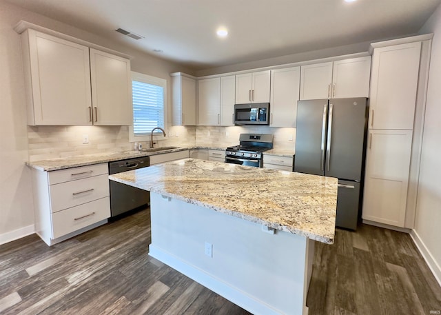 kitchen featuring white cabinets, a kitchen island, dark wood-type flooring, and stainless steel appliances