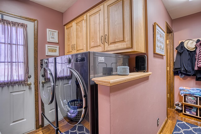 laundry room featuring light hardwood / wood-style flooring, cabinets, and separate washer and dryer