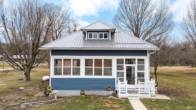 view of front of home with a sunroom and a front lawn