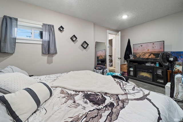 carpeted bedroom with a fireplace and a textured ceiling