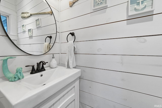 bathroom with wooden walls and vanity