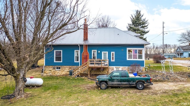 back of house featuring a lawn, a wooden deck, and central air condition unit