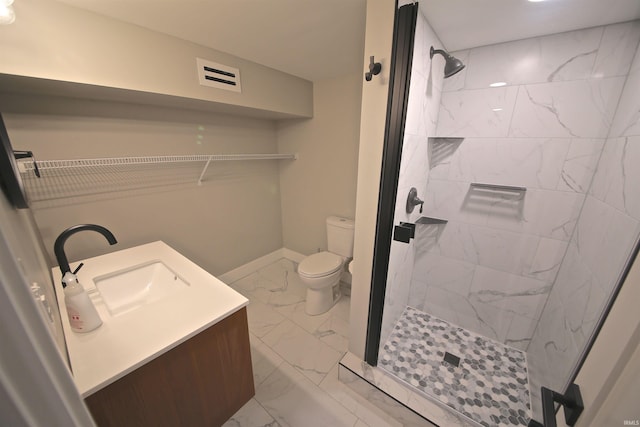 bathroom featuring tile flooring, toilet, a tile shower, and vanity