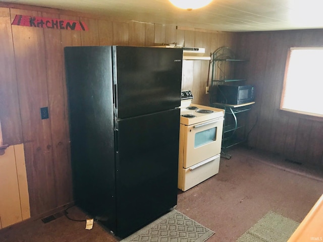 kitchen with radiator heating unit, wood walls, black appliances, and custom exhaust hood