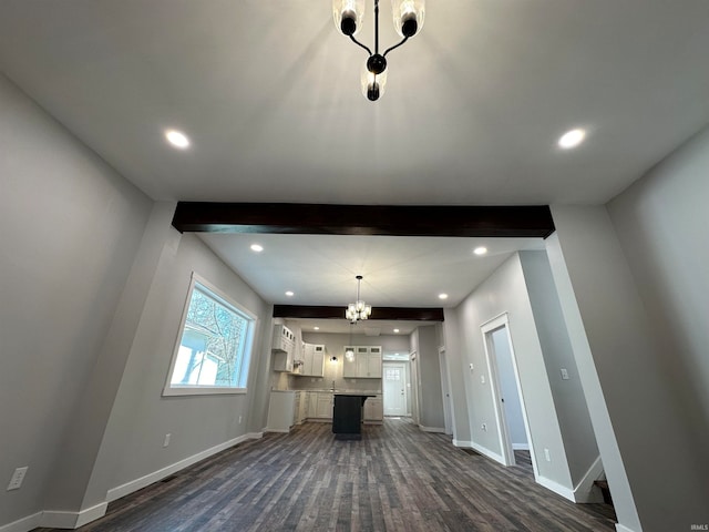 unfurnished living room featuring dark hardwood / wood-style flooring and an inviting chandelier