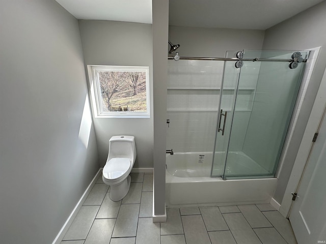 bathroom featuring tile patterned flooring, enclosed tub / shower combo, and toilet