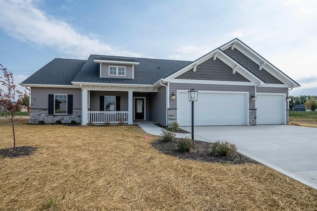 craftsman inspired home featuring a porch, a garage, and a front lawn