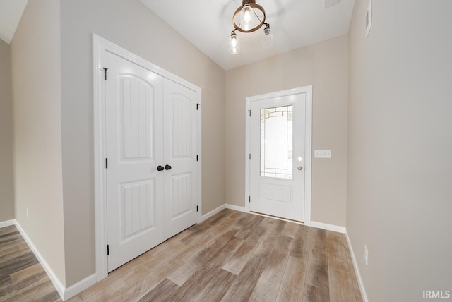 foyer entrance with visible vents, light wood-type flooring, and baseboards