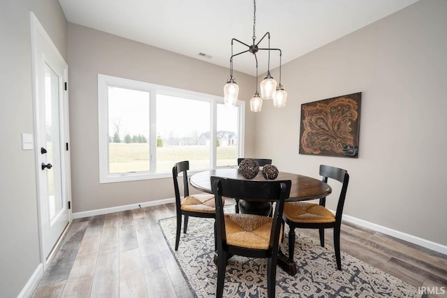 dining space with light wood-type flooring, baseboards, and visible vents