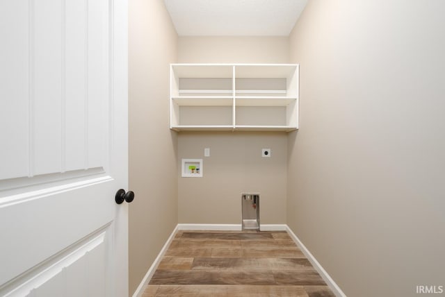 washroom with electric dryer hookup, light wood-type flooring, baseboards, and laundry area