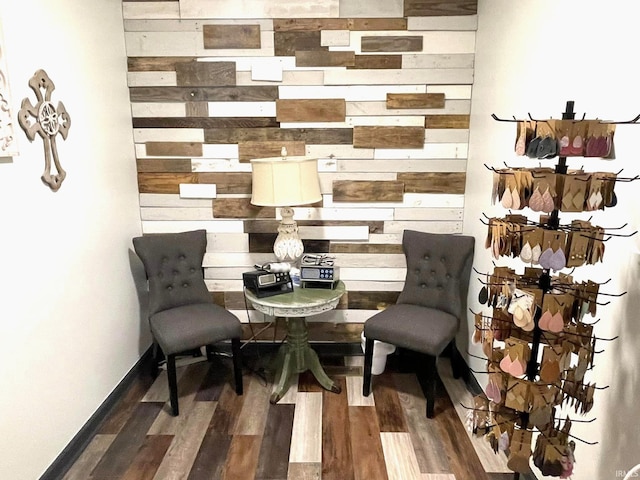 living area featuring wood walls and dark hardwood / wood-style flooring