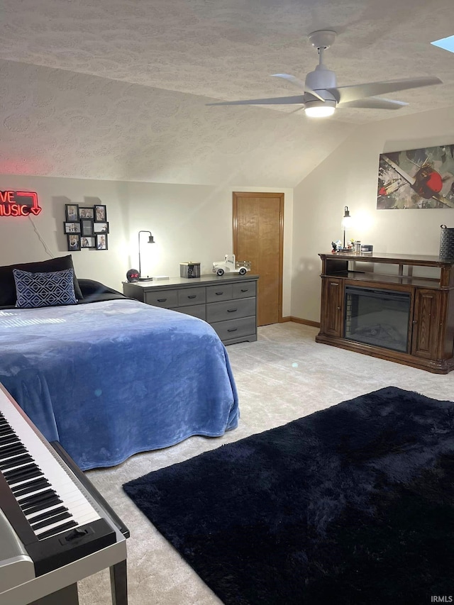 bedroom with ceiling fan, a textured ceiling, light colored carpet, and vaulted ceiling