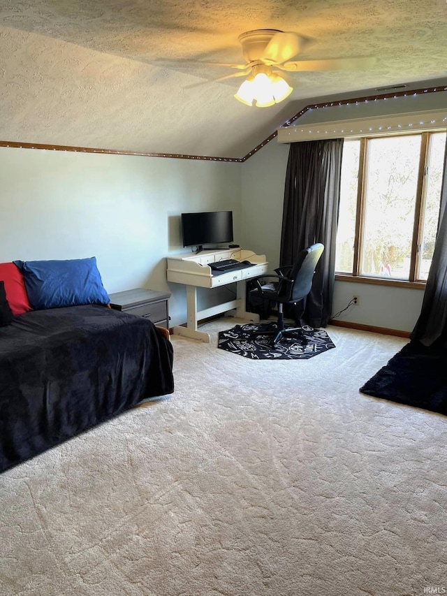 carpeted bedroom with vaulted ceiling, ceiling fan, and a textured ceiling