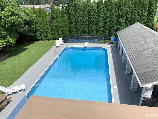 view of pool with a lawn