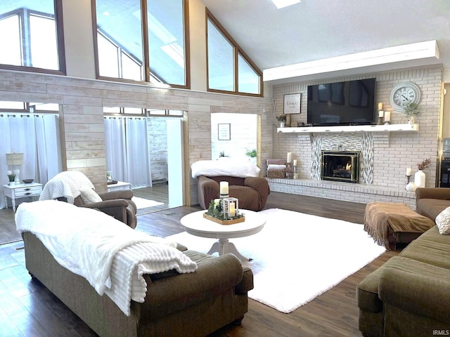 living room with a textured ceiling, high vaulted ceiling, dark hardwood / wood-style flooring, and a fireplace