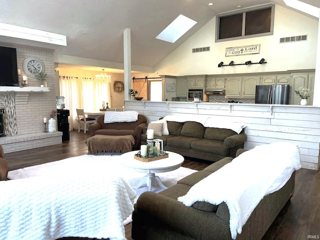 living room featuring dark hardwood / wood-style flooring, high vaulted ceiling, a brick fireplace, and a skylight