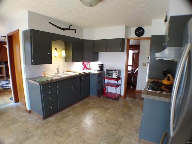 kitchen with light tile flooring, sink, cooktop, and backsplash