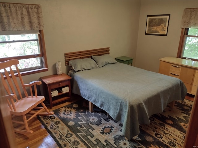 bedroom featuring multiple windows and dark hardwood / wood-style flooring