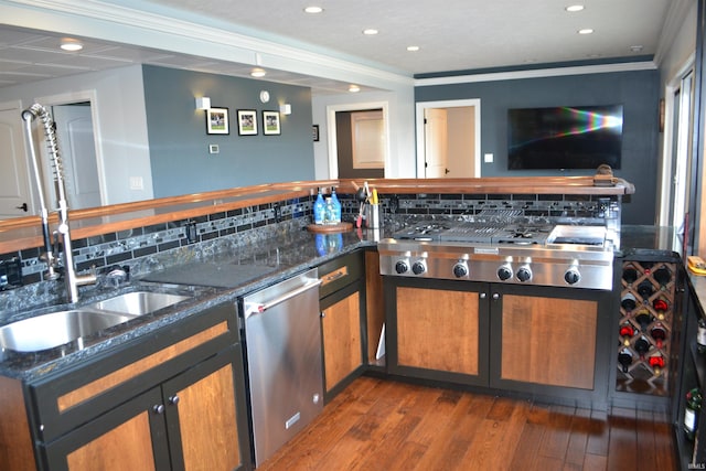 kitchen featuring dark hardwood / wood-style floors, appliances with stainless steel finishes, dark stone countertops, tasteful backsplash, and crown molding