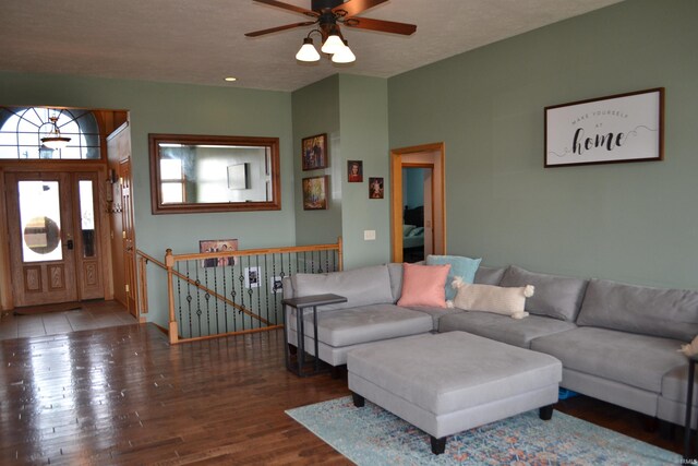 living room featuring ceiling fan and dark hardwood / wood-style floors