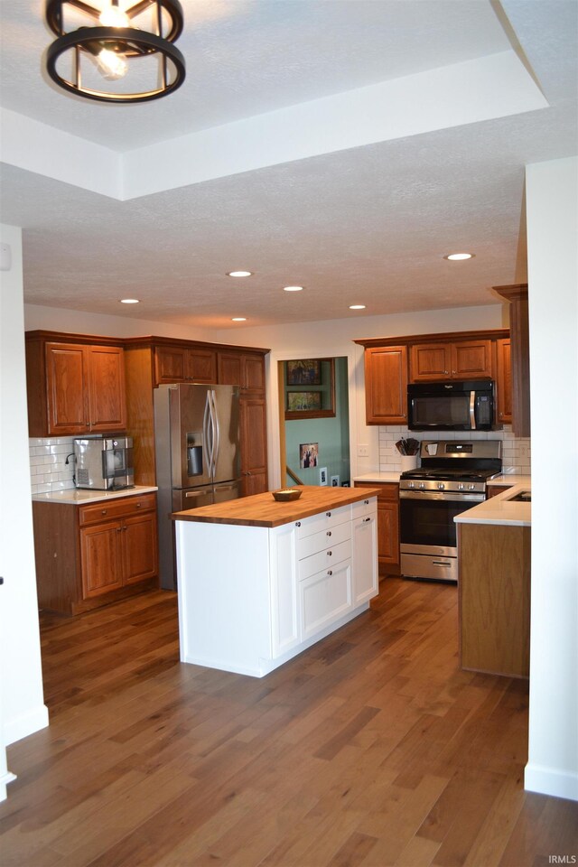 kitchen featuring an inviting chandelier, tasteful backsplash, dark hardwood / wood-style flooring, and stainless steel appliances