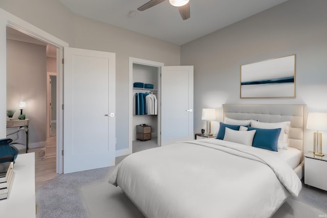 bedroom with a walk in closet, a closet, light wood-type flooring, and ceiling fan