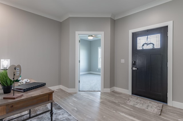 entrance foyer featuring ornamental molding, light wood-type flooring, and ceiling fan