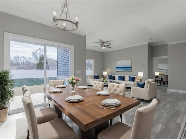 dining space featuring hardwood / wood-style floors, crown molding, and ceiling fan with notable chandelier