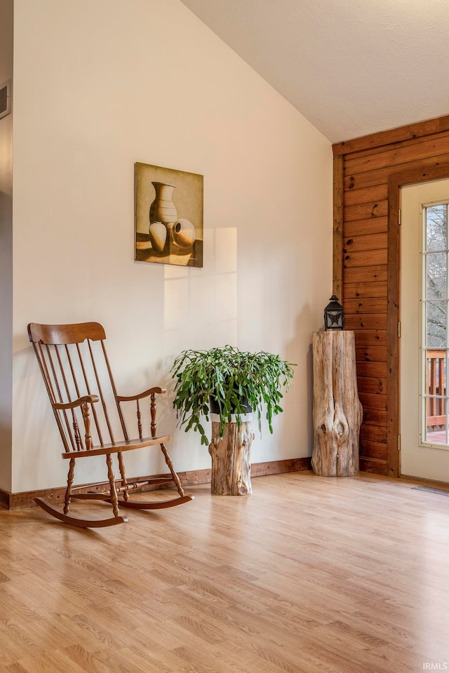 living area featuring wood walls and light wood-type flooring