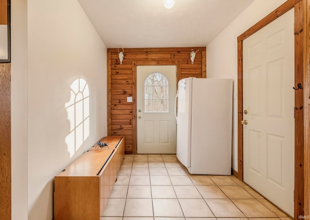 foyer entrance featuring wooden walls and light tile floors