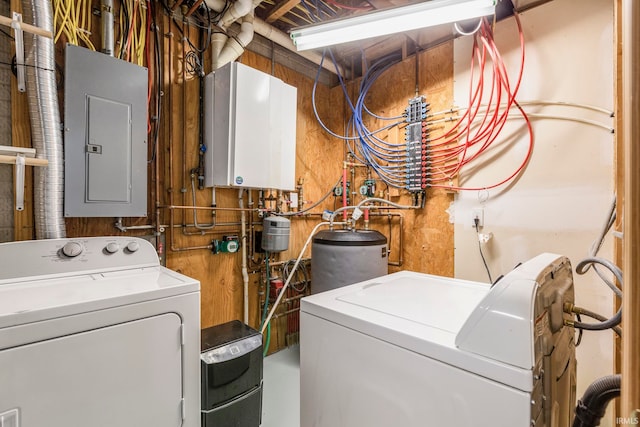 washroom with water heater and washing machine and dryer