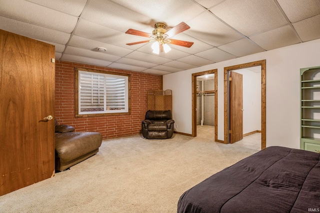 bedroom featuring ceiling fan, a paneled ceiling, light carpet, and a spacious closet