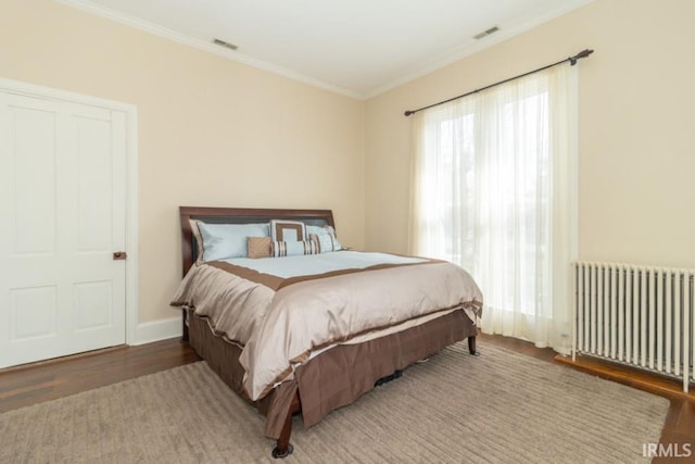 bedroom with crown molding, dark wood-type flooring, and radiator