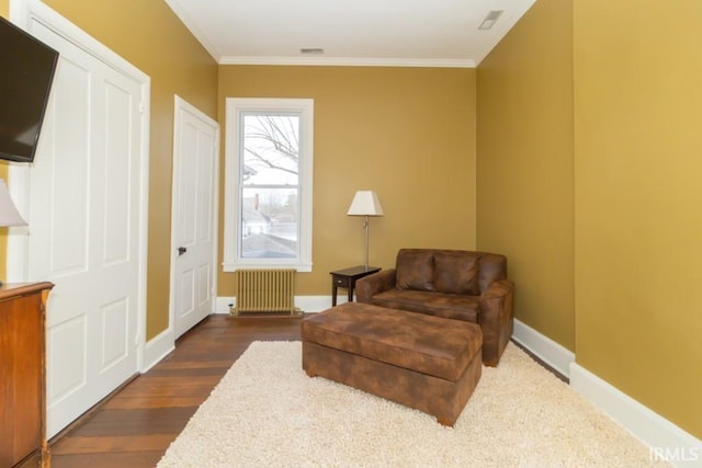 living area featuring dark hardwood / wood-style flooring, ornamental molding, and radiator