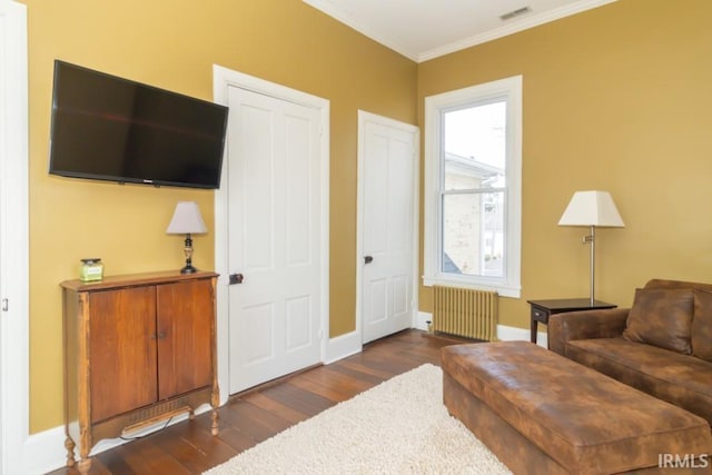 living area featuring radiator heating unit, crown molding, dark hardwood / wood-style floors, and a healthy amount of sunlight