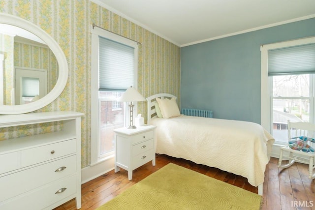 bedroom with radiator, dark hardwood / wood-style floors, and crown molding