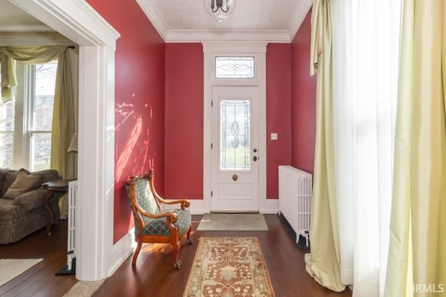 entryway with radiator heating unit, ornamental molding, and dark hardwood / wood-style floors