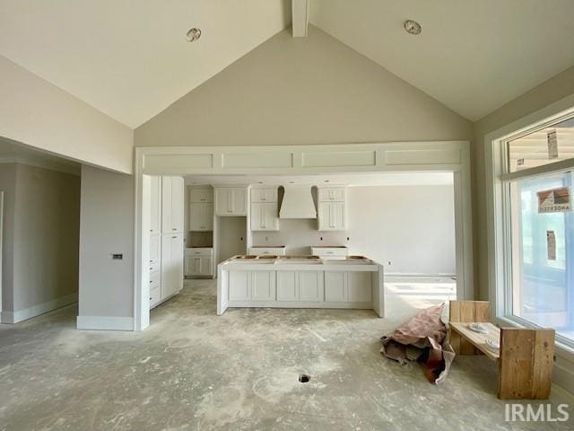 kitchen featuring beam ceiling, white cabinetry, premium range hood, and high vaulted ceiling