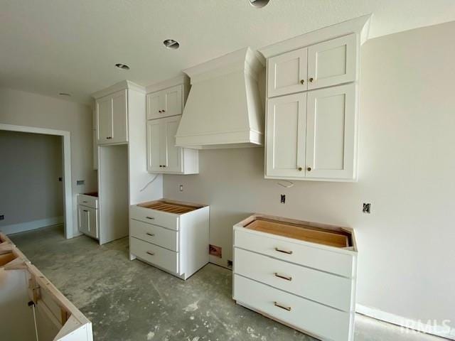 kitchen with premium range hood and white cabinetry