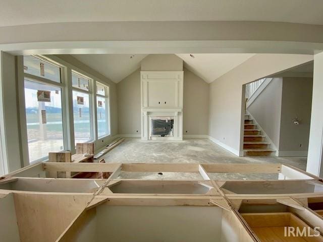 unfurnished living room featuring vaulted ceiling