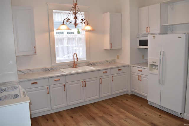 kitchen with hanging light fixtures, white cabinets, white appliances, and sink