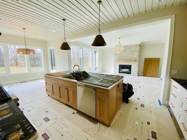 kitchen with decorative light fixtures, stainless steel dishwasher, an island with sink, and plenty of natural light