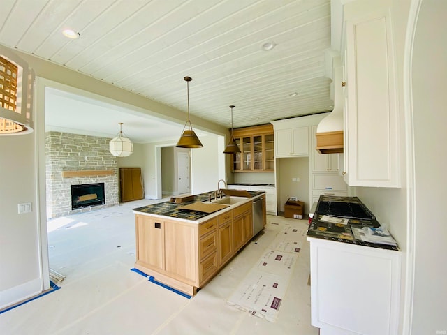 kitchen with an island with sink, pendant lighting, brick wall, dishwasher, and sink