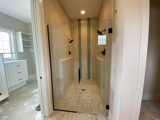 bathroom with a shower with shower door and a healthy amount of sunlight